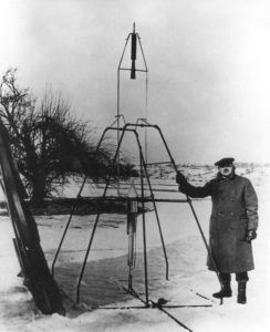 Robert Goddard, rocket, and launching frame at his Aunt's farm in Auburn, MA (1926).