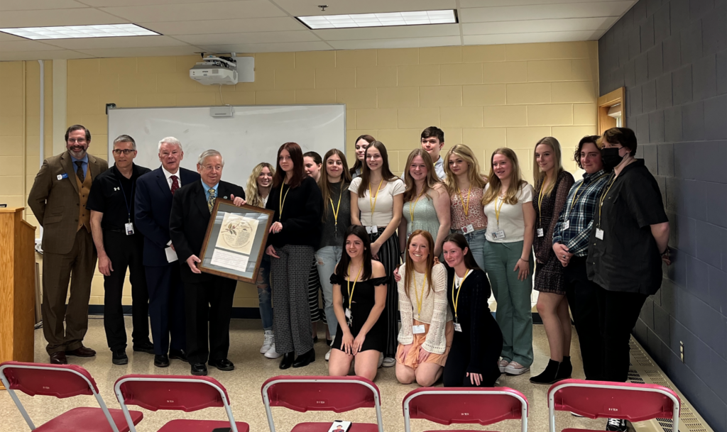 At a ceremony held on April 11, 2022, at Blackstone Valley Tech, Blackstone Heritage Corridor presented its 2021John H. Chafee Student Award to 17 sophomore students from the Painting and Design Technology program at Blackstone Valley Tech. Pictured here from left to right (standing): Devon Kurtz, Blackstone River Valley National Heritage Corridor Executive Director; Tom Lamont, Painting & Design Technology instructor at Blackstone Valley Tech; Dr. Michael Fitzpatrick, Blackstone Valley Tech Superintendent; Richard T. Moore, Blackstone River Valley National Heritage Corridor Board Chair; Amelie Botelho (Millbury), Giana Duquette (Milford), Nelle Norris (Milford), Katie Huff (Douglas), Stella Lentini (Milford), Emma Fiore (Grafton), Emma Sanborn (Milford), Jonathon Spiller (Northbridge), Marley Koopman (Northbridge), Madison Moore (Millbury), Hailey Feehan (Northbridge), Logan Feehan (Northbridge), and Alexandra Nunnemacher (Sutton). From left to right (kneeling): Madison Collins (Grafton), Sophie Jacobson (Bellingham), and Riley Austin (Northbridge). Not pictured: Carlie Jensen (Grafton). Photo by Molly Cardoza.